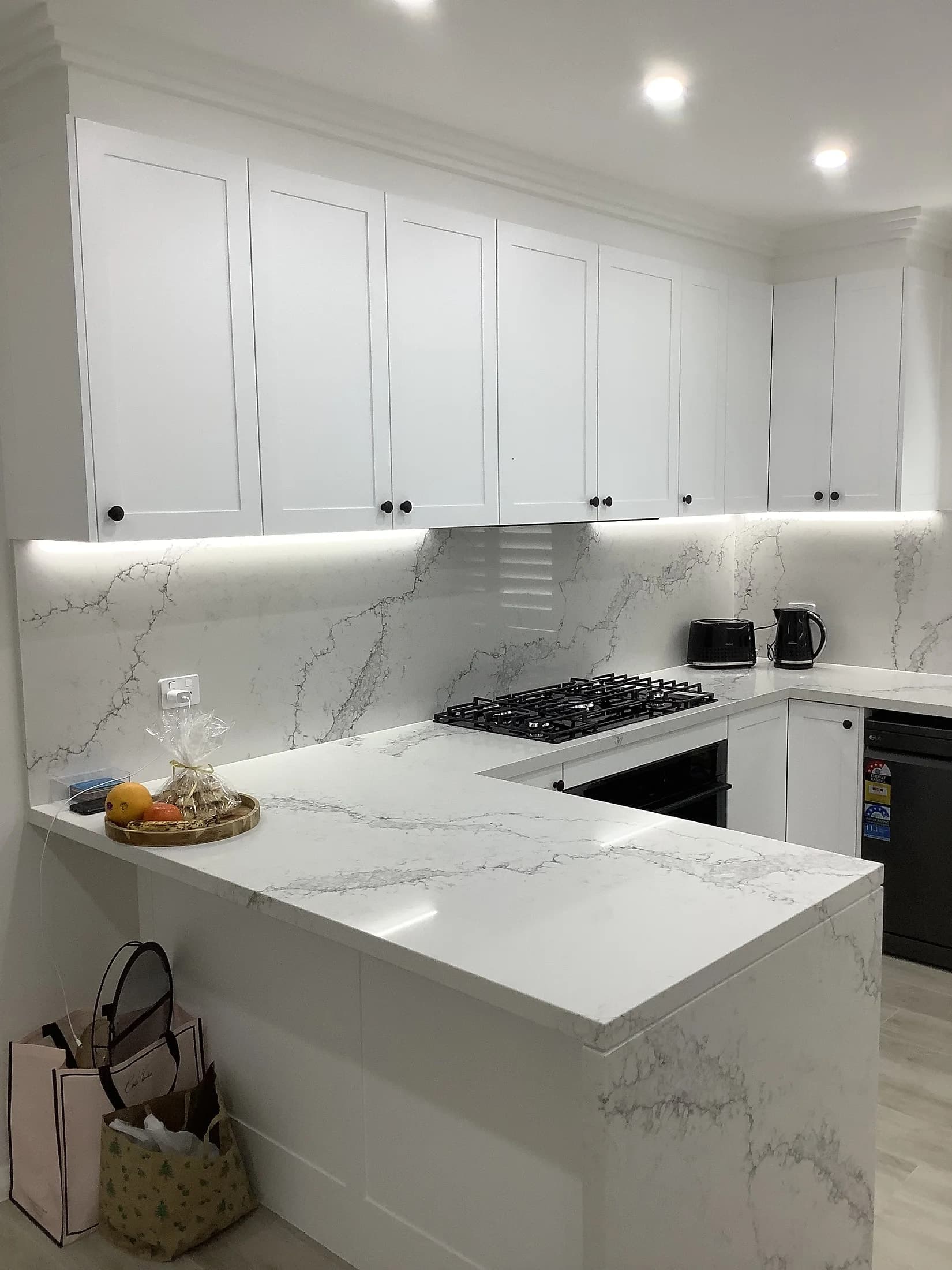 Guildford kitchen with white shaker cabinetry, a marble-look waterfall benchtop and full-height splashback
