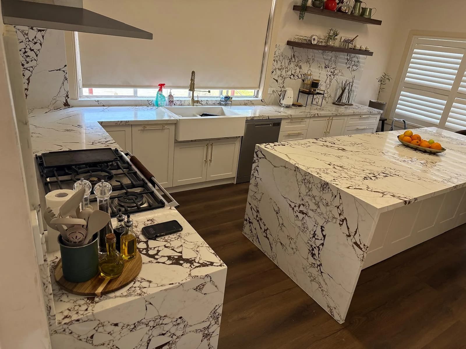 Completed Guildford kitchen with white shaker cabinetry and marble-look island surfaces